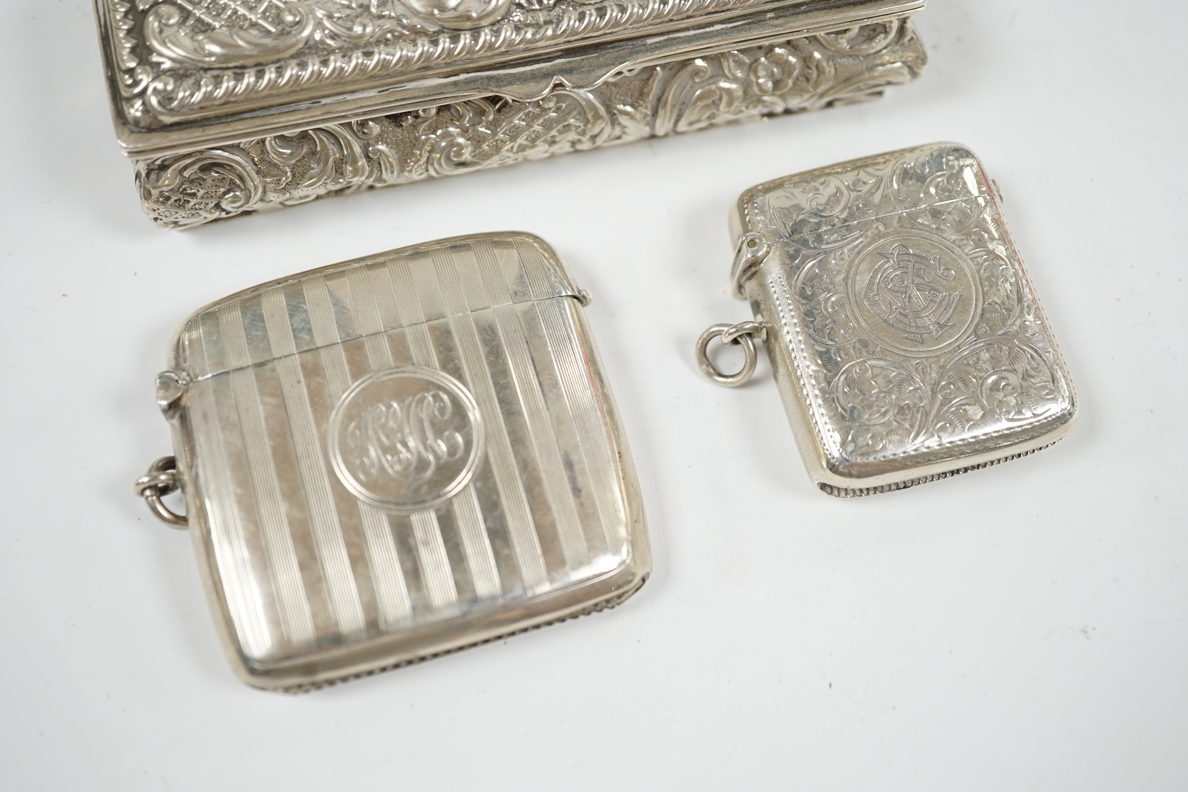 Two early 20th century silver vesta cases and an Edwardian repousse silver trinket box, 11cm. Condition - fair
